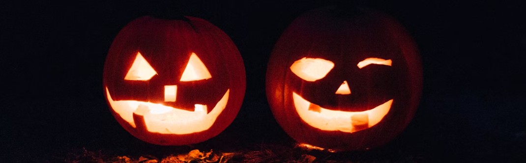 Två karvade pumpor med svart bakgrund